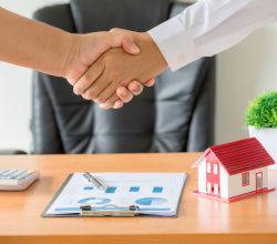 Side view hands of agent and client shaking hands after signed contract buy new apartment.